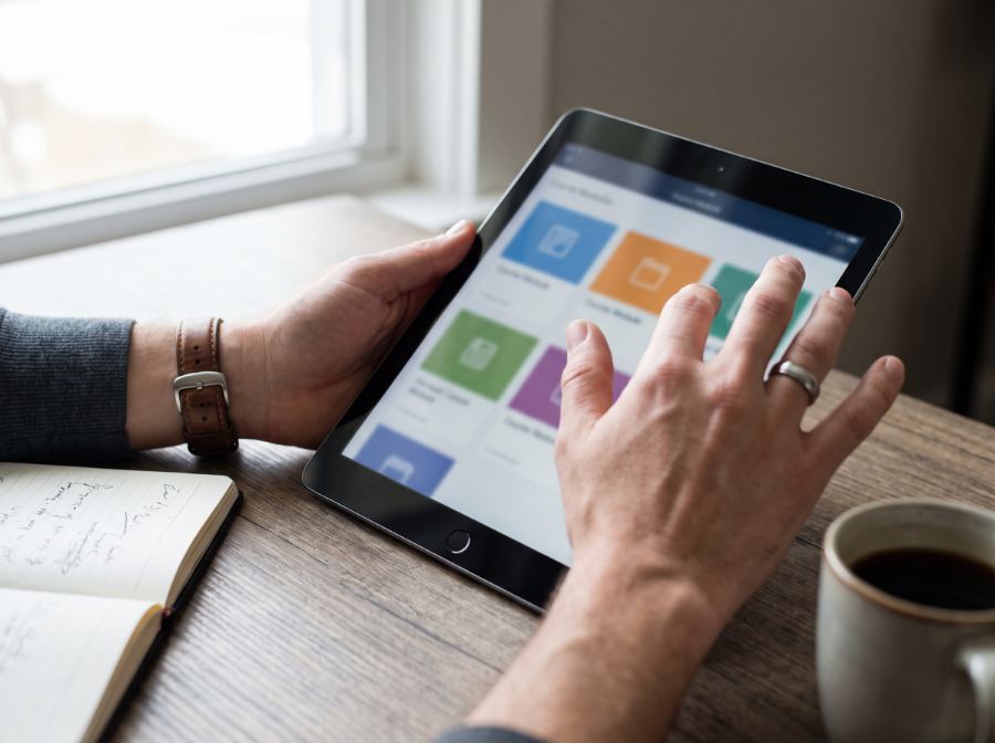 Pessoa navegando em um catálogo de cursos no tablet